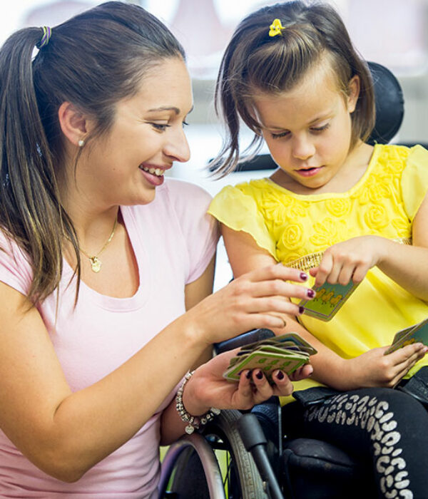 Child looking at educational cards while in wheelchair