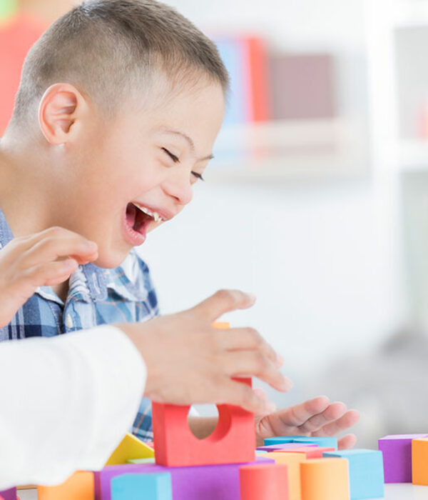 Child smiling/laughing playing with blocks