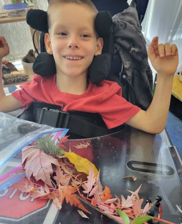 Student playing with leaves